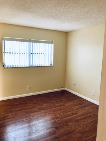 a view of a room with wooden floor and a window