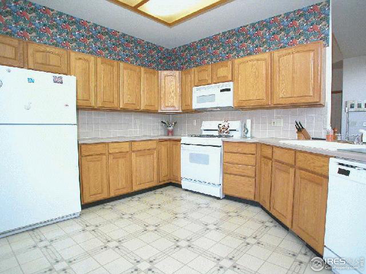 704 Rider Ridge Place Longmont, CO 80504 - Photo 3 of 12 a kitchen with a sink a stove a refrigerator and cabinets