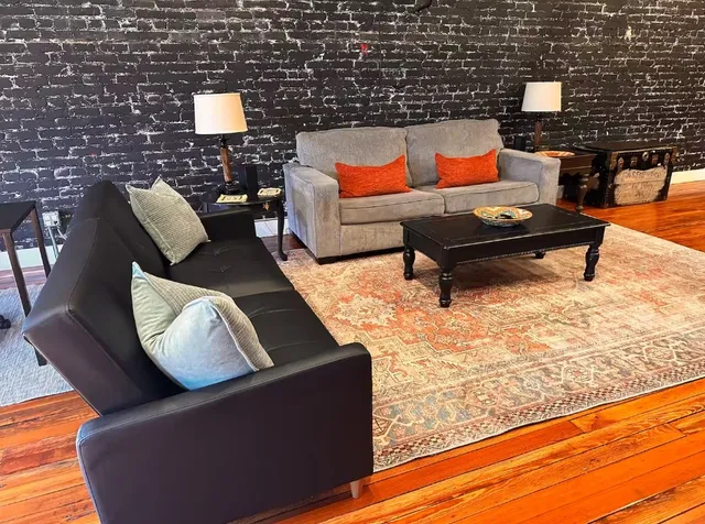 a living room with furniture and a wooden floor