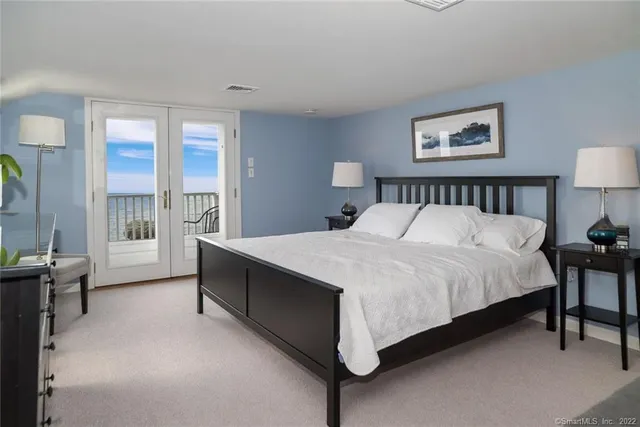 a large bed sitting in a bedroom next to a window