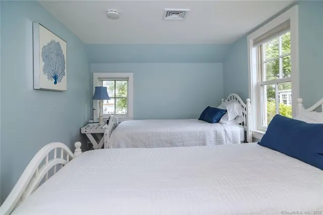 a bedroom with two beds and a window