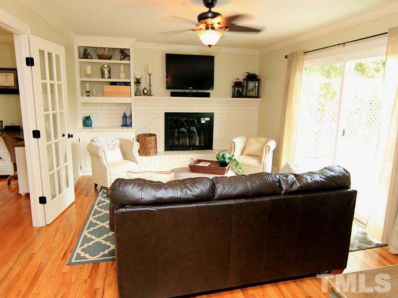 5016 Stonehill Drive Raleigh, NC 27609 - Photo 11 of 22 a living room with furniture a flat screen tv and a fireplace
