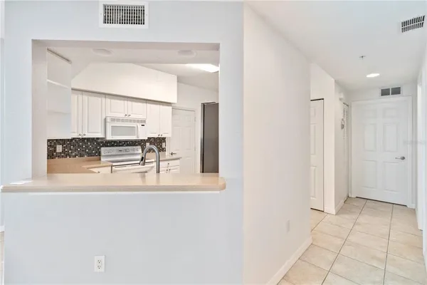 a view of kitchen with refrigerator and cabinets