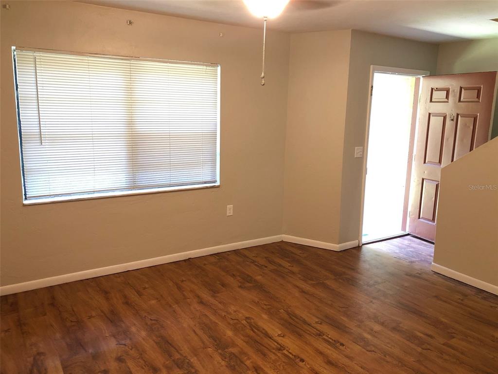 6818 Southwest 42nd Place, Unit D Gainesville, FL 32608 - Photo 3 of 16 an empty room with wooden floor and windows
