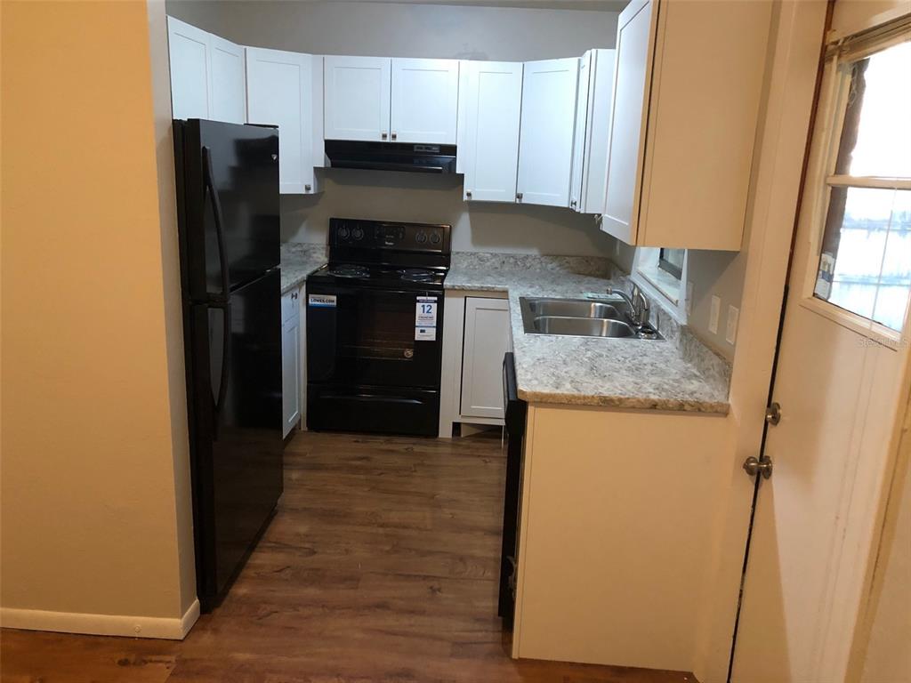 6818 Southwest 42nd Place, Unit D Gainesville, FL 32608 - Photo 4 of 16 a kitchen with granite countertop stainless steel appliances a refrigerator and a stove top oven