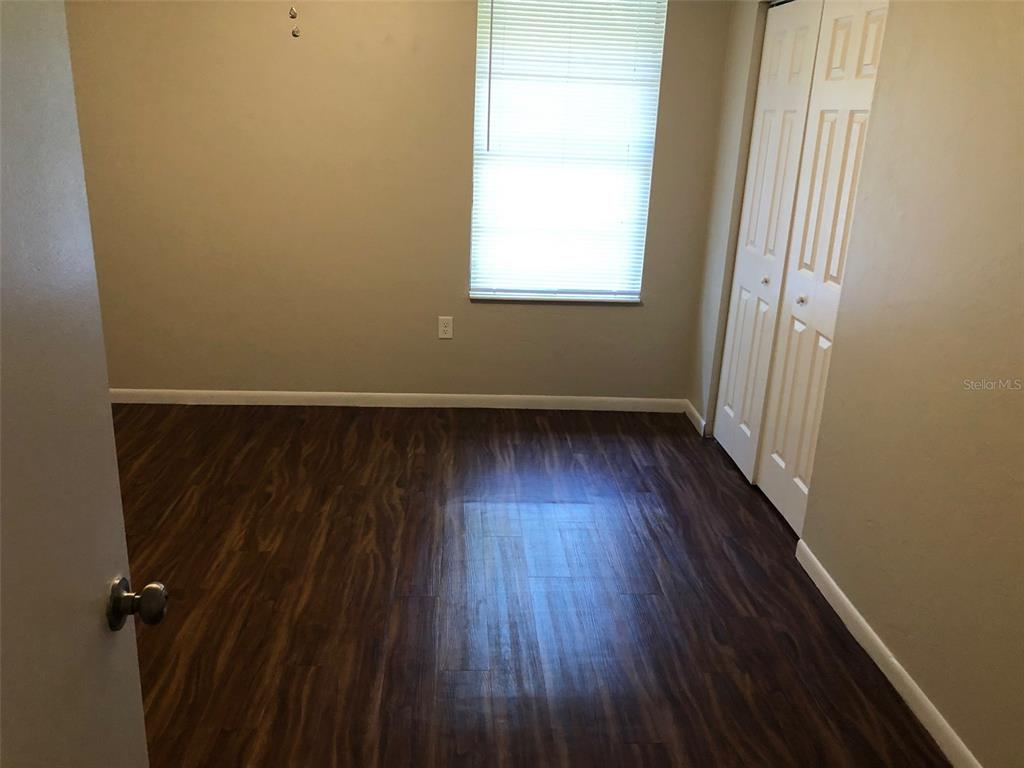 6818 Southwest 42nd Place, Unit D Gainesville, FL 32608 - Photo 8 of 16 an empty room with wooden floor and windows