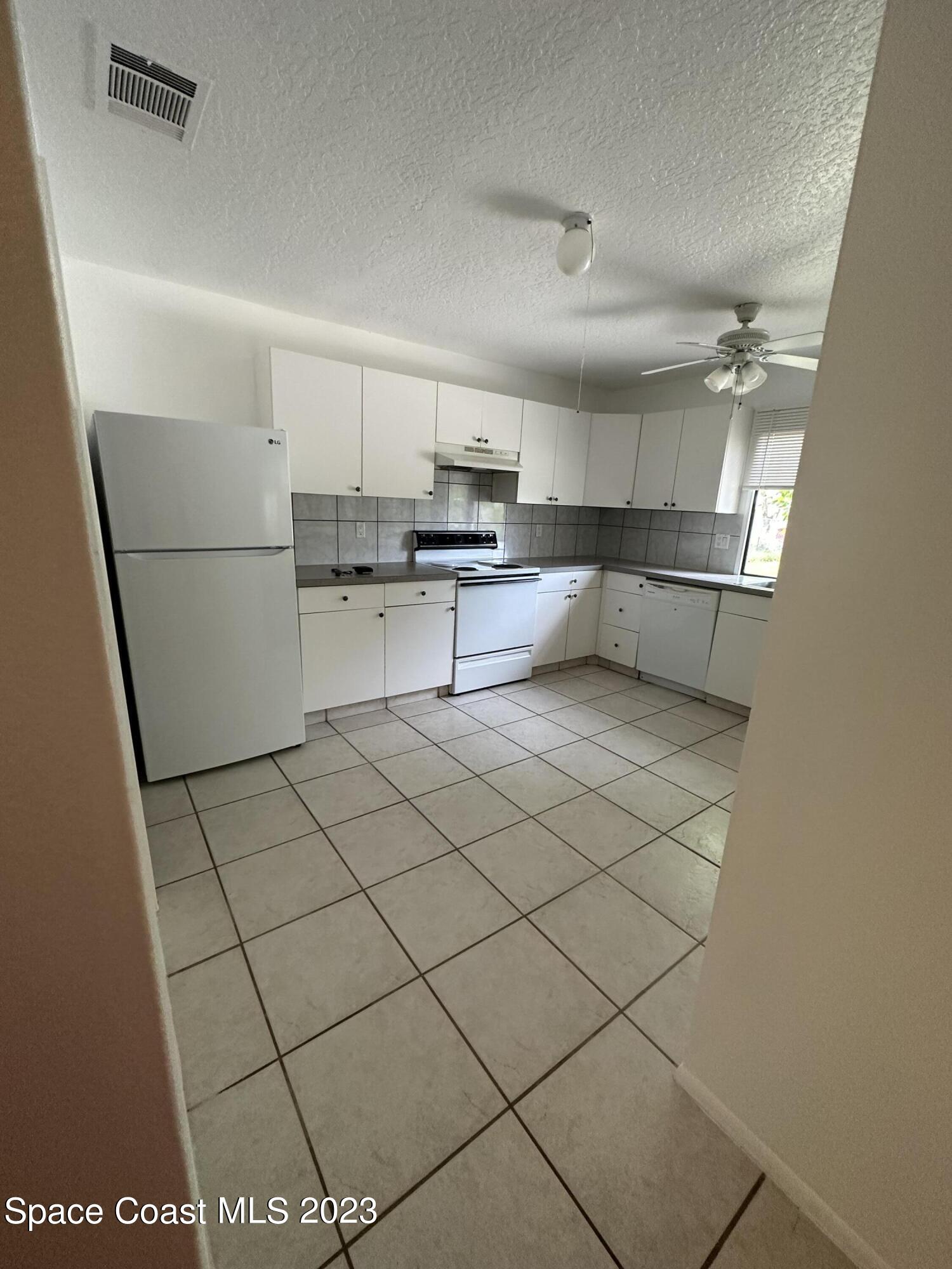 1331 Creel Road Northeast Palm Bay, FL 32905 - Photo 13 of 21 a kitchen with stainless steel appliances refrigerator sink and cabinets