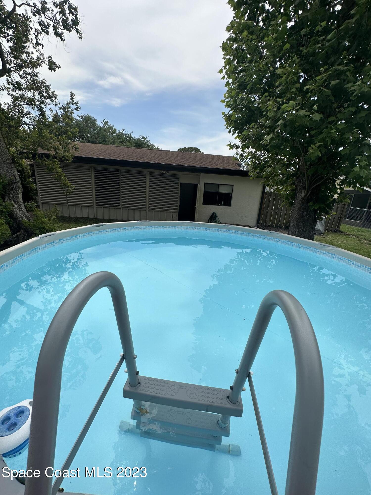 1331 Creel Road Northeast Palm Bay, FL 32905 - Photo 18 of 21 a backyard of a house with table and chairs