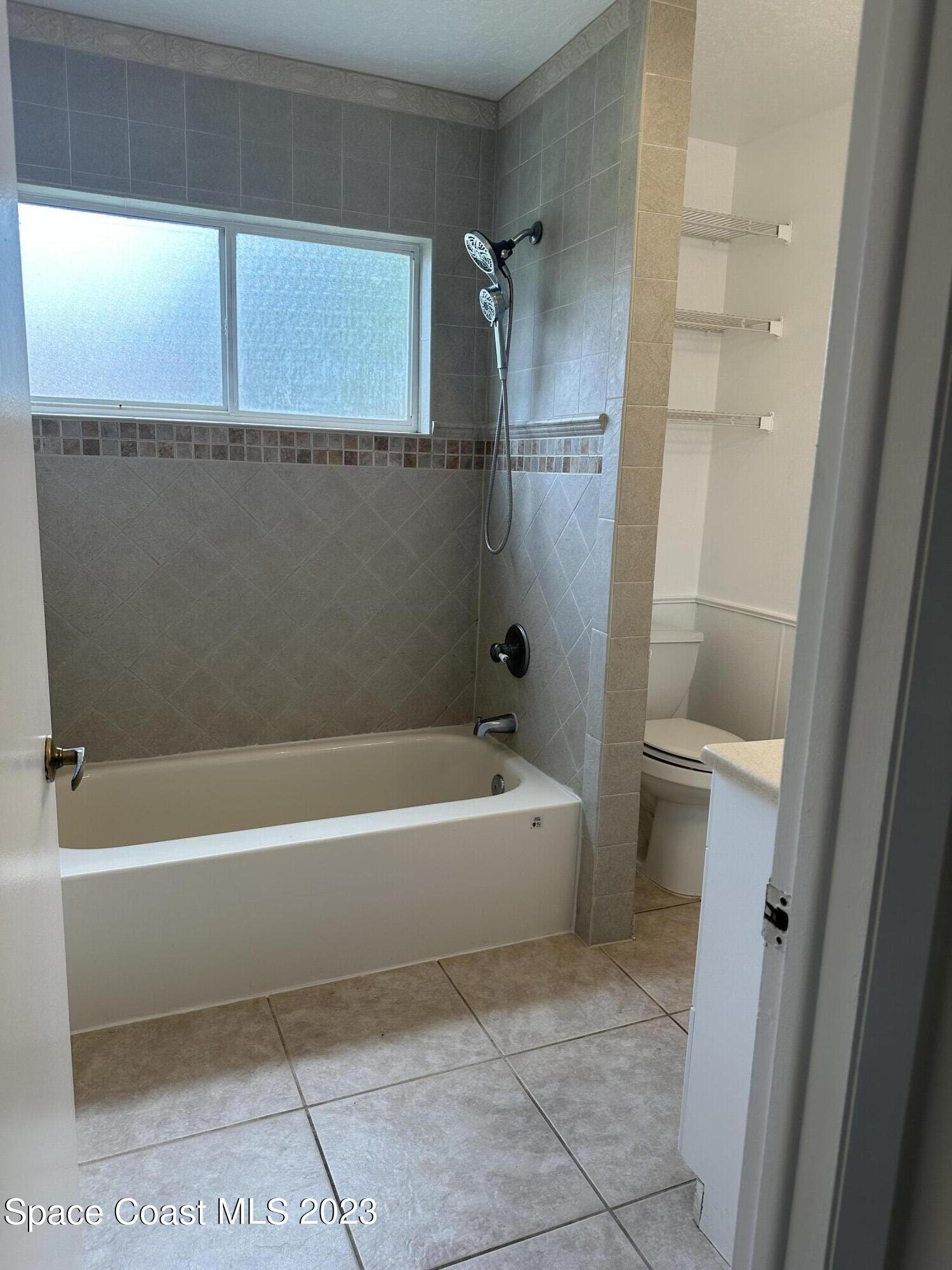 1331 Creel Road Northeast Palm Bay, FL 32905 - Photo 2 of 21 a bathroom with a bathtub and a shower