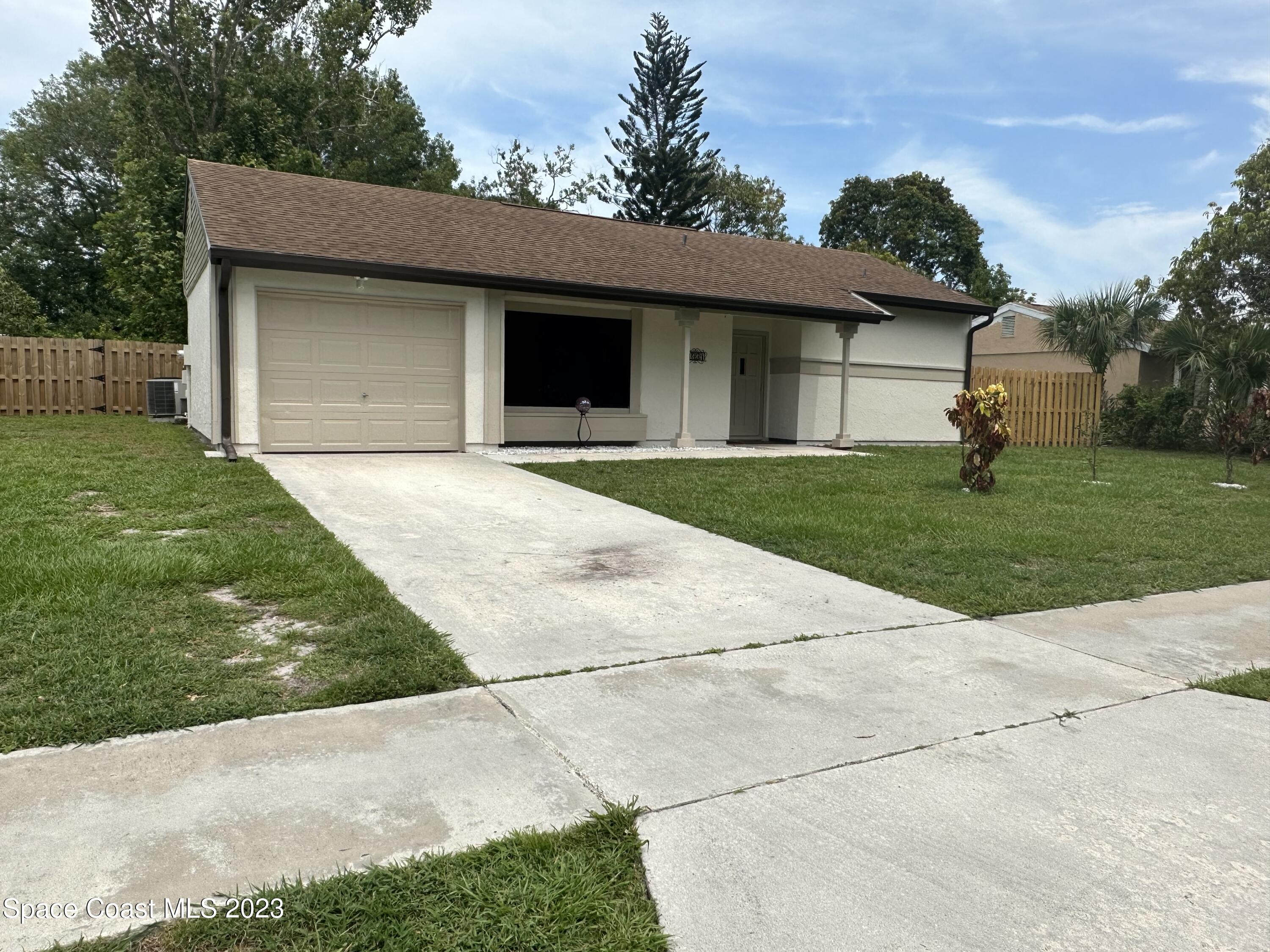 1331 Creel Road Northeast Palm Bay, FL 32905 - Photo 21 of 21 a front view of a house with a garden and trees