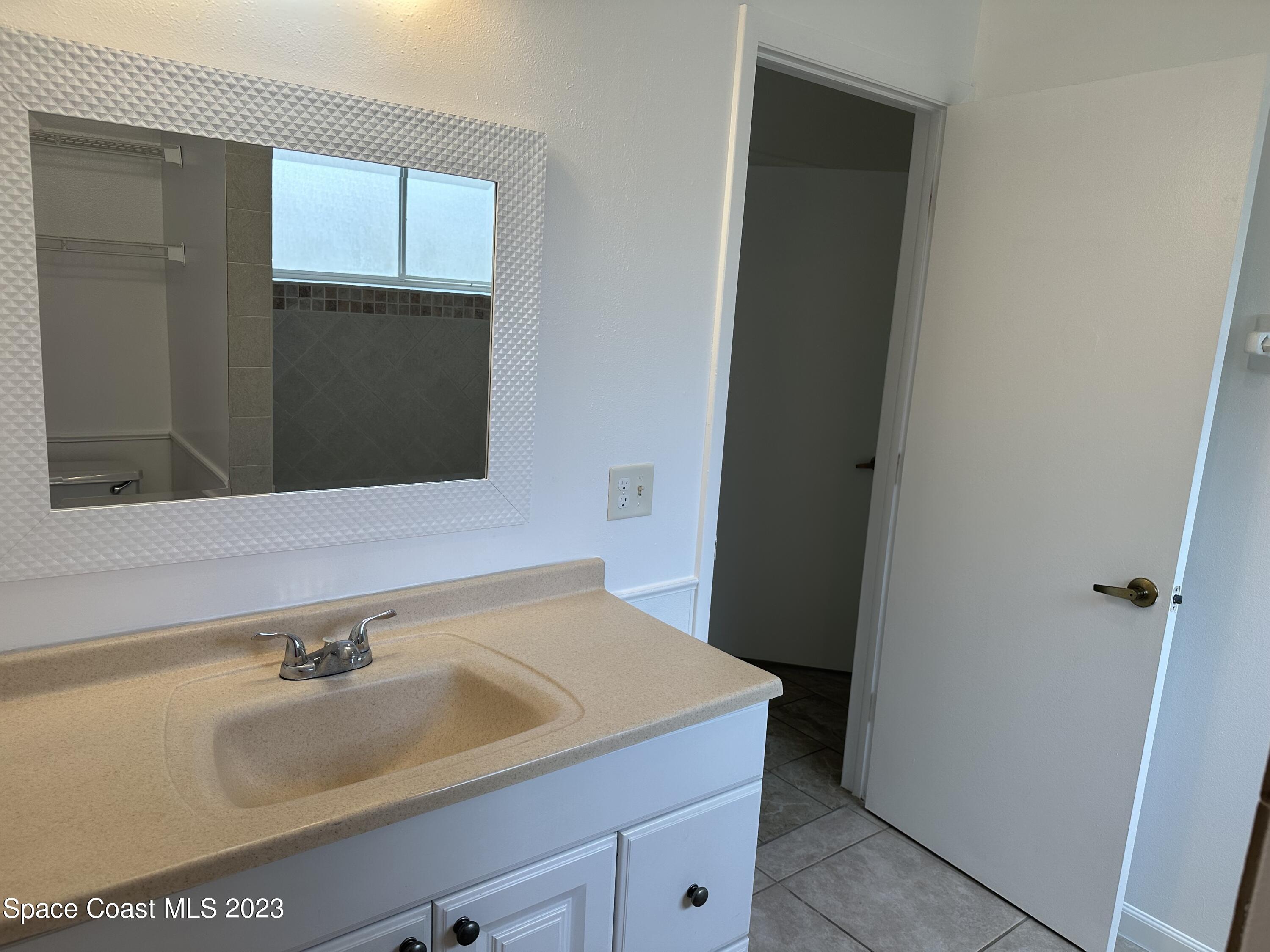 1331 Creel Road Northeast Palm Bay, FL 32905 - Photo 3 of 21 a bathroom with a sink and a mirror