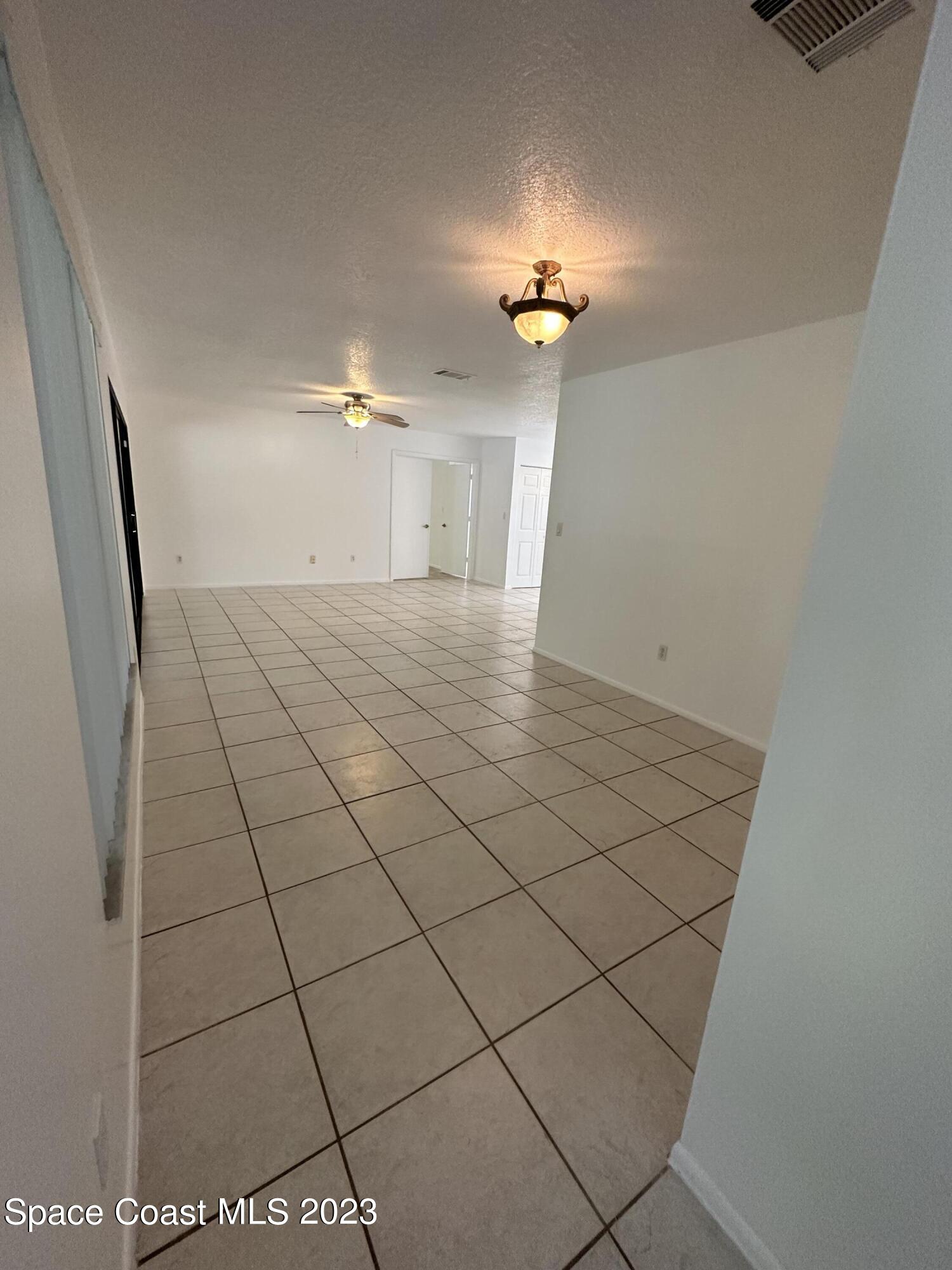 1331 Creel Road Northeast Palm Bay, FL 32905 - Photo 7 of 21 a view of a livingroom with wooden floor and a chandelier