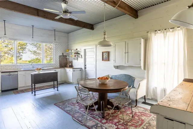 a living room with dining table and a large window