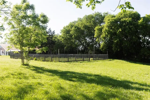 a view of a swimming pool with a yard and large trees