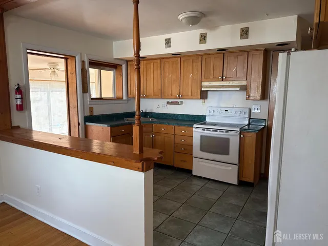 a kitchen with stainless steel appliances a sink a stove a refrigerator and cabinets
