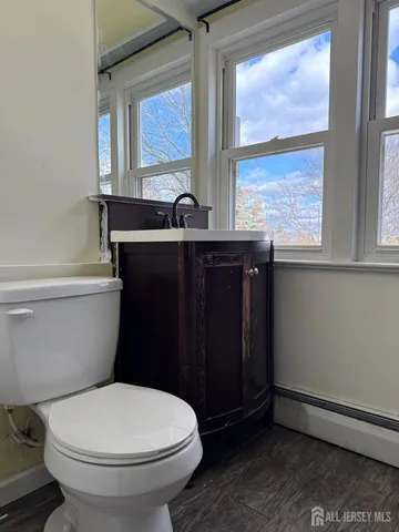 a bathroom with a toilet a sink and a window