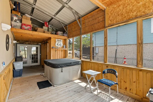 a view of a patio with table and chairs with wooden floor and fence