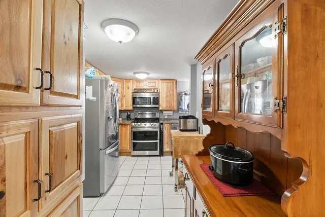 a kitchen with stainless steel appliances kitchen island granite countertop a stove and a refrigerator