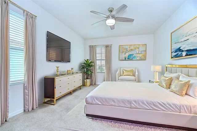 a spacious bedroom with a bed and a flat screen tv