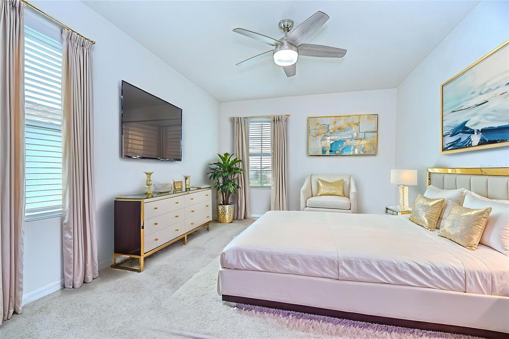 1382 Crescent Hoop Way Wesley Chapel, FL 33543 - Photo 13 of 27 a spacious bedroom with a bed and a flat screen tv
