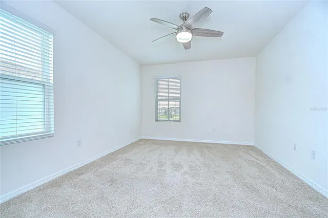 an empty room with a window and a fan