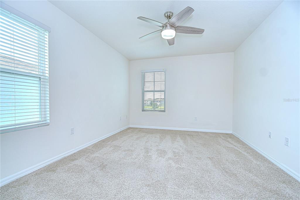 1382 Crescent Hoop Way Wesley Chapel, FL 33543 - Photo 14 of 27 an empty room with a window and a fan