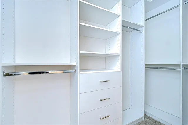 a view of walk in closet with empty racks
