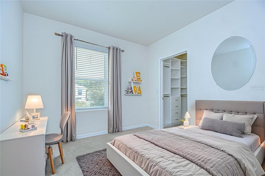 1382 Crescent Hoop Way Wesley Chapel, FL 33543 - Photo 19 of 27 a bedroom with a bed and a window