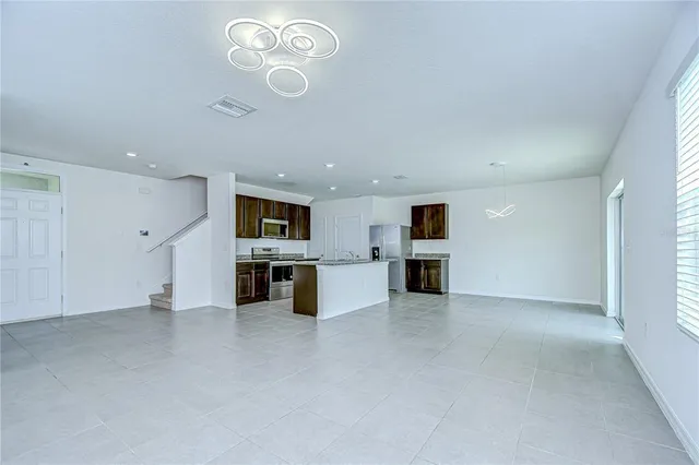 an empty room with kitchen and refrigerator