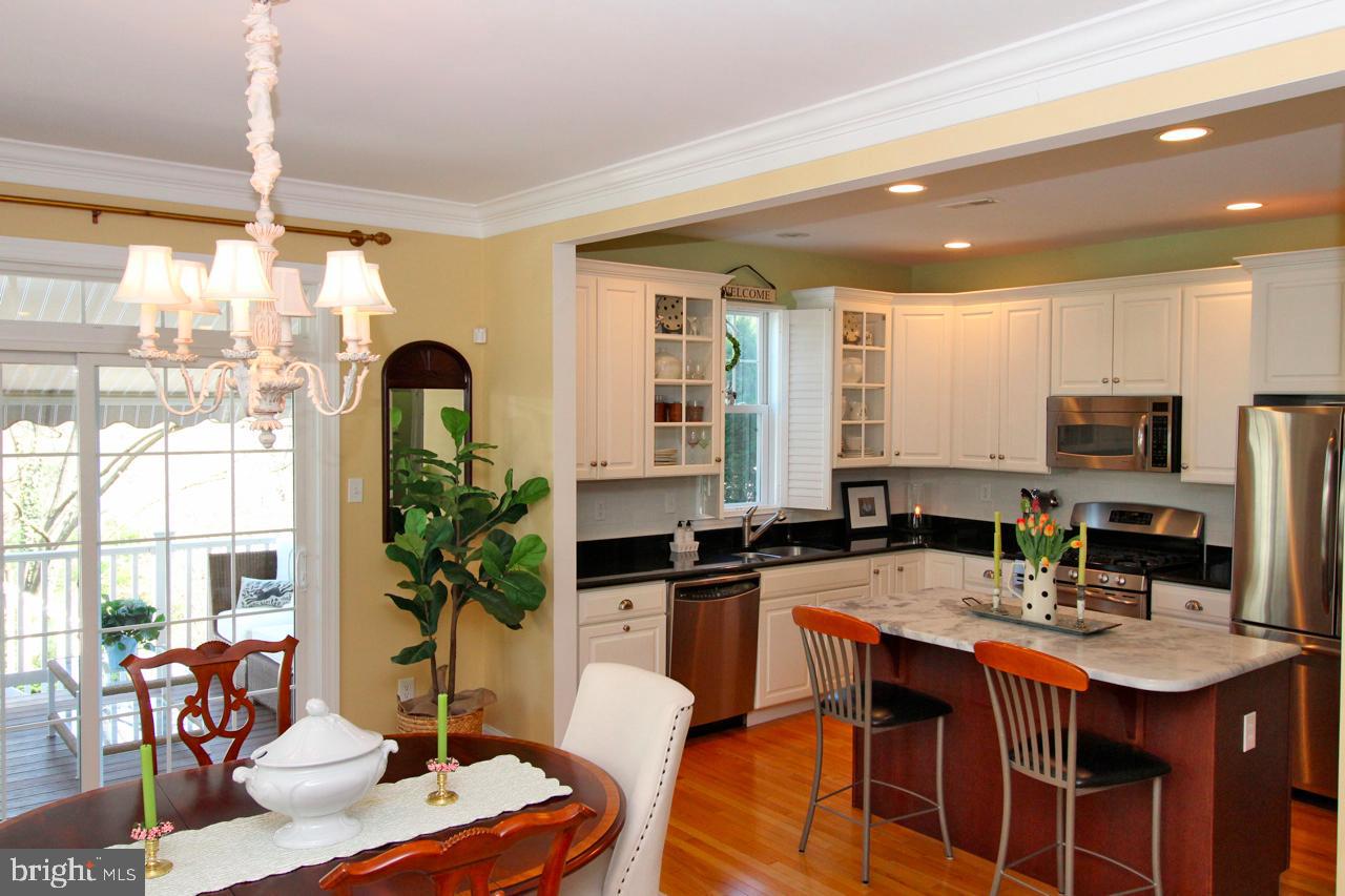 117 West 5th Street Media, PA 19063 - Photo 10 of 54 a kitchen with stainless steel appliances granite countertop a stove a refrigerator a sink a dining table and chairs with wooden floor