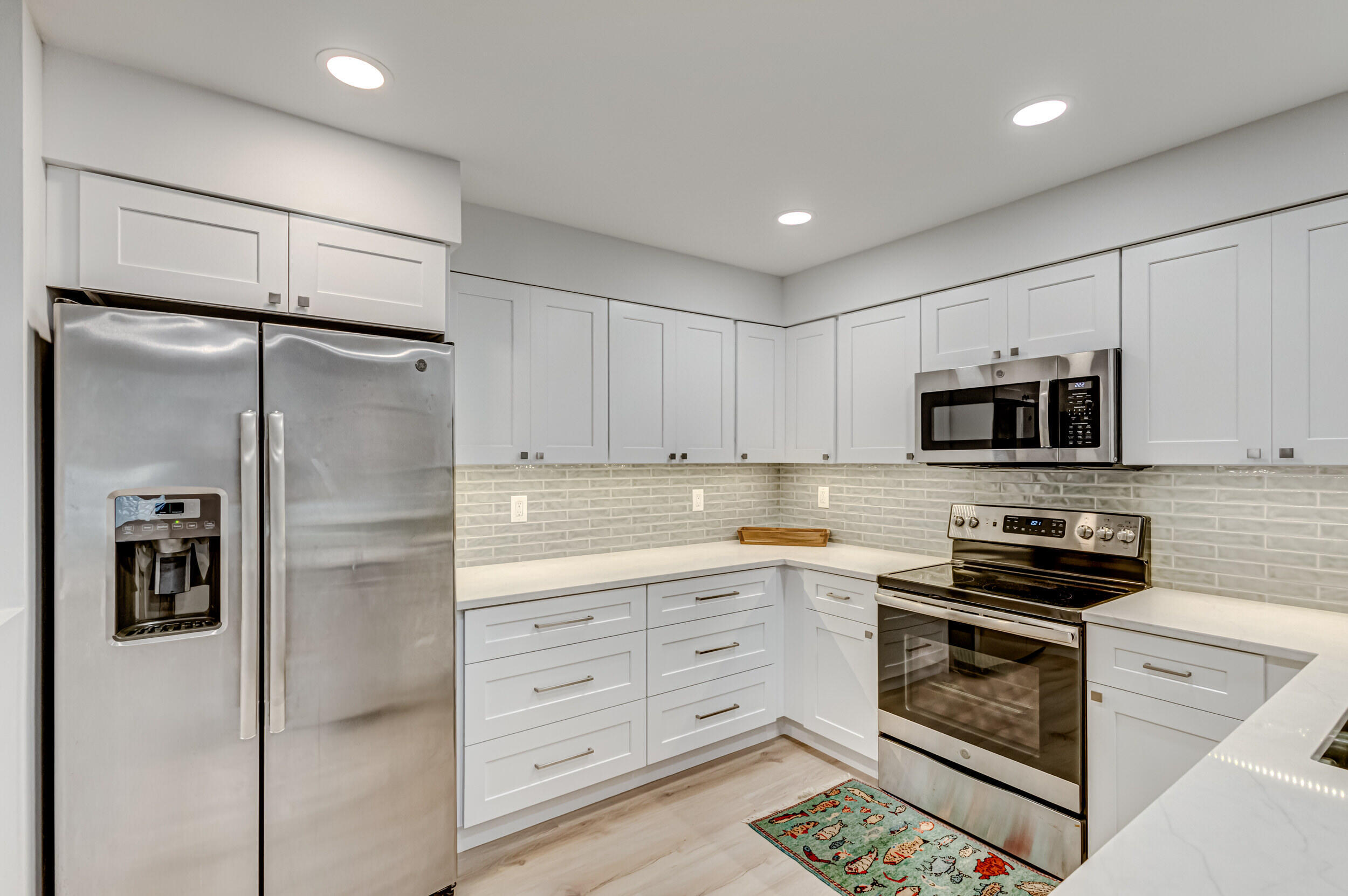 207 Mainsail Circle Jupiter, FL 33477 - Photo 11 of 56 a kitchen with stainless steel appliances white cabinets and a refrigerator