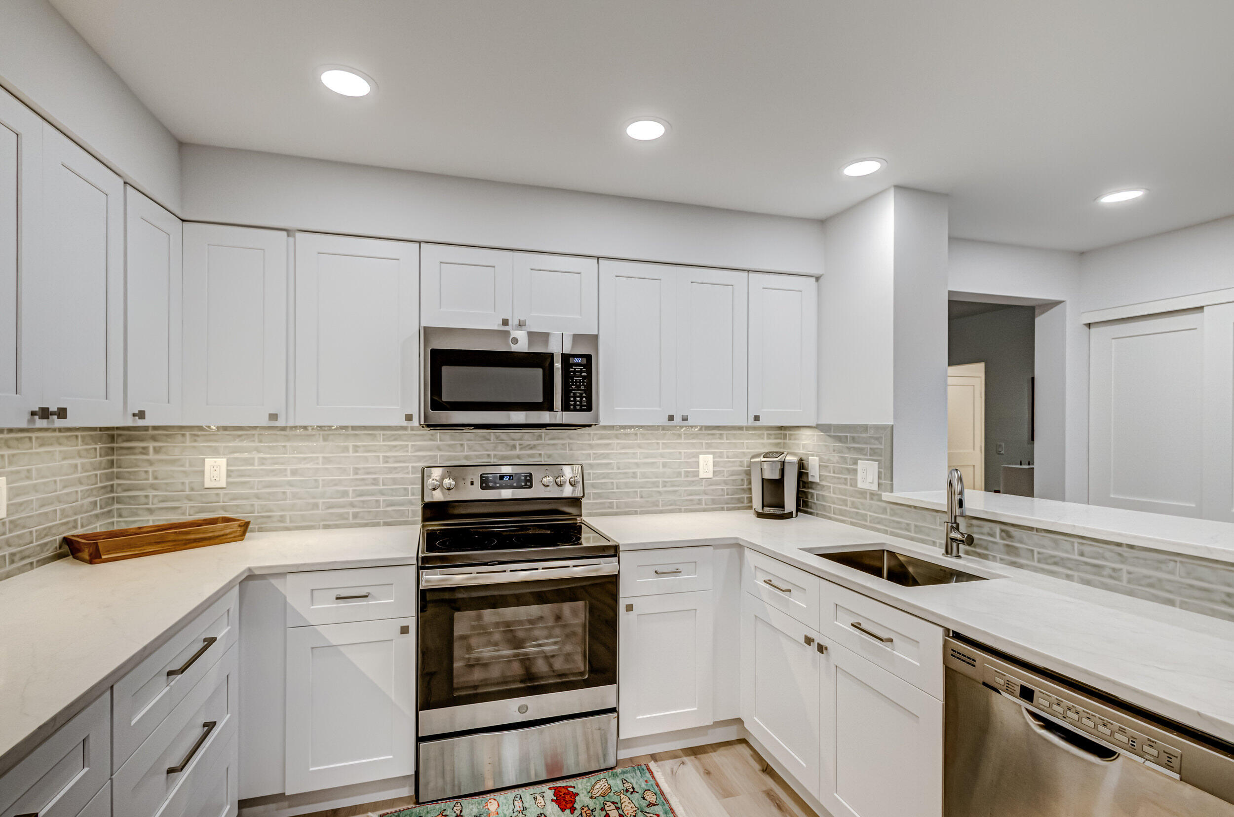 207 Mainsail Circle Jupiter, FL 33477 - Photo 12 of 56 a kitchen with white cabinets stainless steel appliances and sink