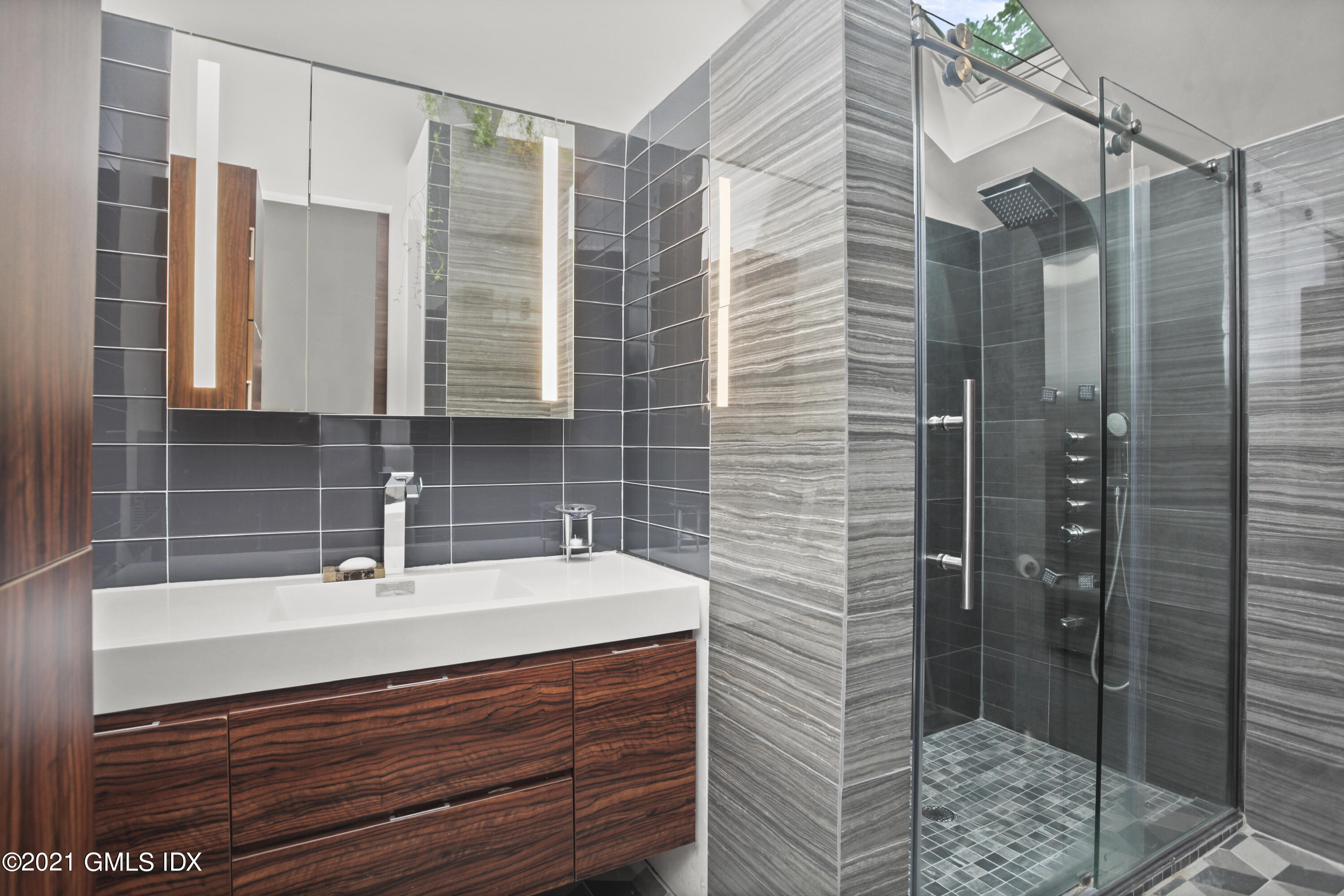 49 Mill Brook Road, Unit WEST Stamford, CT 06902 - Photo 24 of 37 a bathroom with a sink a mirror and shower