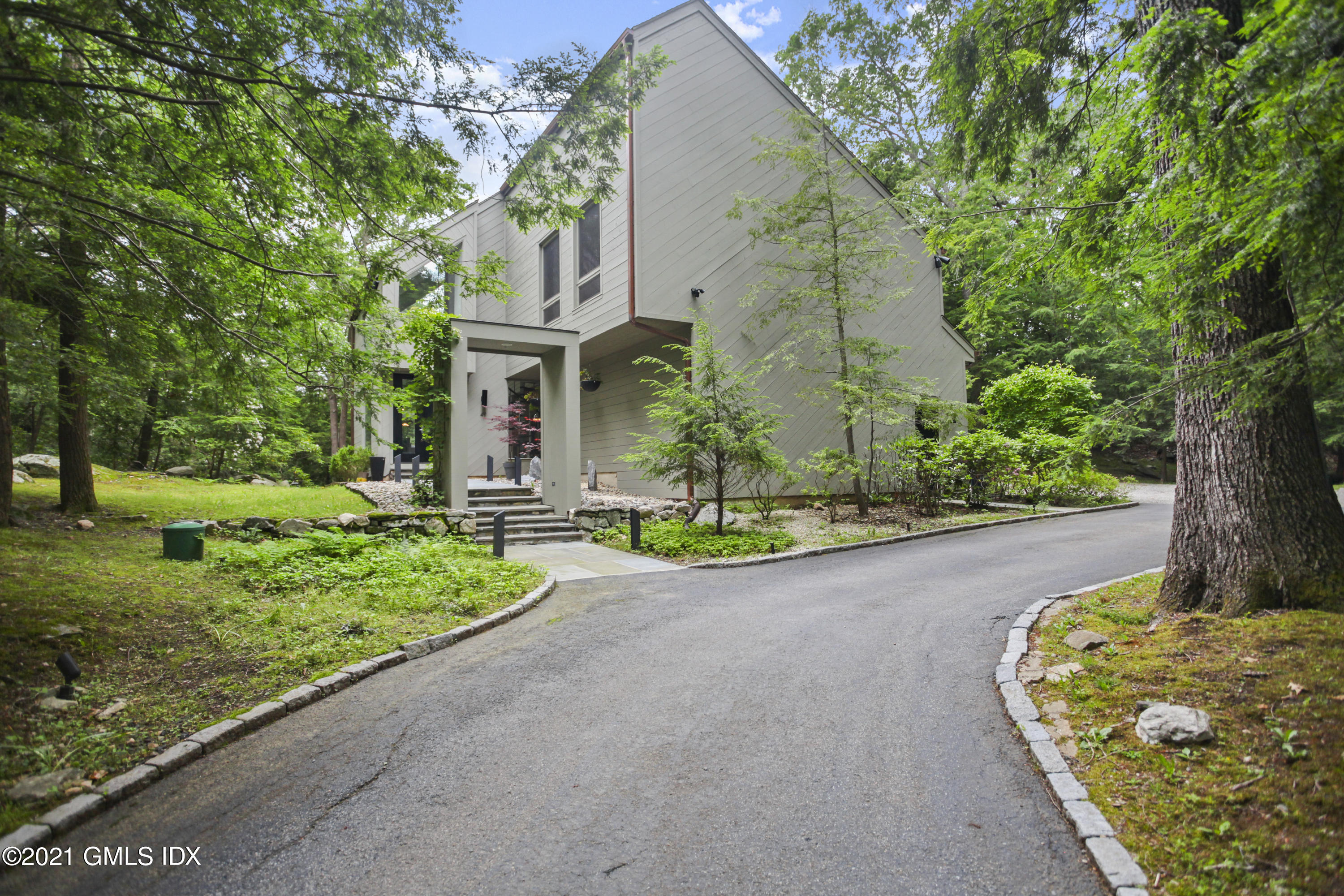 49 Mill Brook Road, Unit WEST Stamford, CT 06902 - Photo 33 of 37 a front view of a house with a yard and a garage