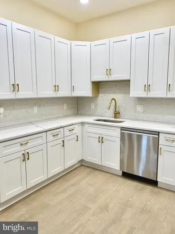 a kitchen with granite countertop white cabinets and white stainless steel appliances