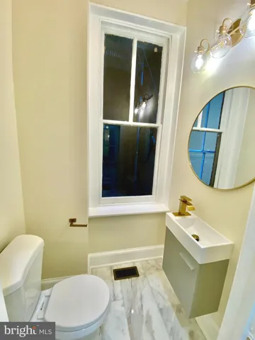 a bathroom with a toilet a sink and a mirror