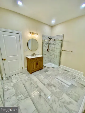 a bathroom with a granite countertop sink a mirror and shower