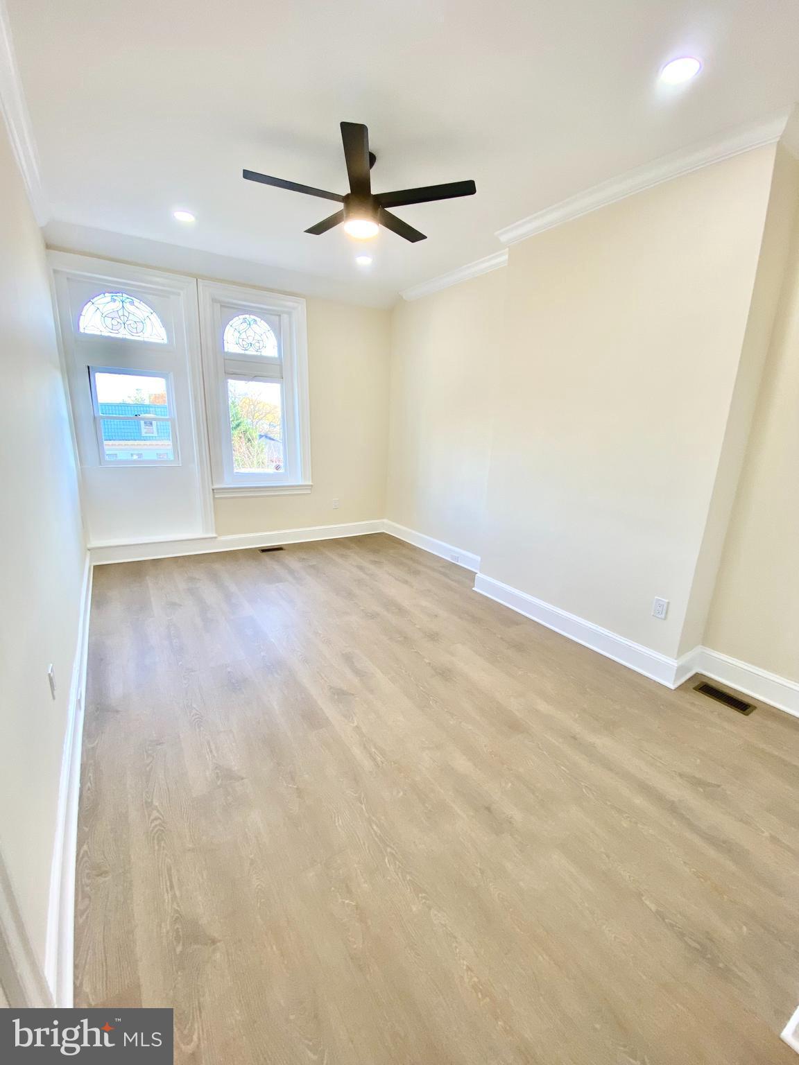 2428 Eutaw Place Baltimore, MD 21217 - Photo 31 of 48 an empty room with windows and ceiling fan