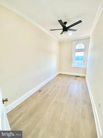 a view of a room with a ceiling fan and wooden floor