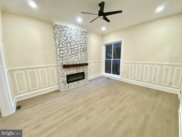 a view of an empty room with a fireplace and a window
