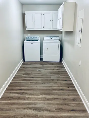 a room with a stove and white cabinets