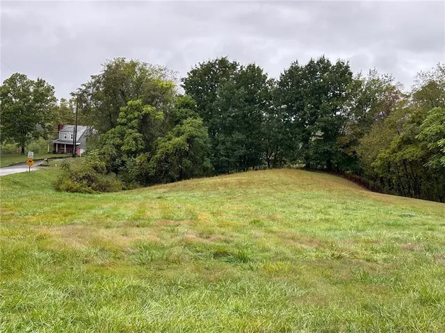 a view of a green field with wooden fence