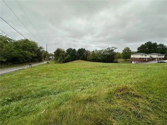 a view of a green field with wooden fence