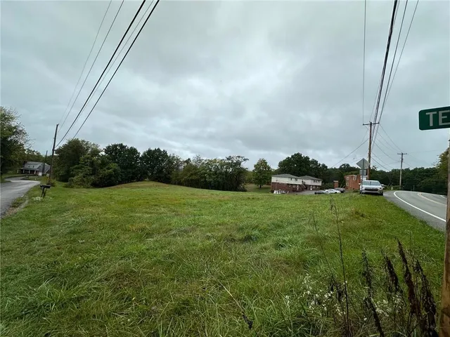 a view of a field of grass and trees