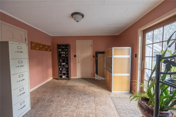 a view of an empty room with window and cabinet