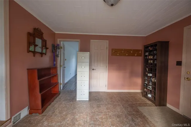 a view of an empty room with closet and a window