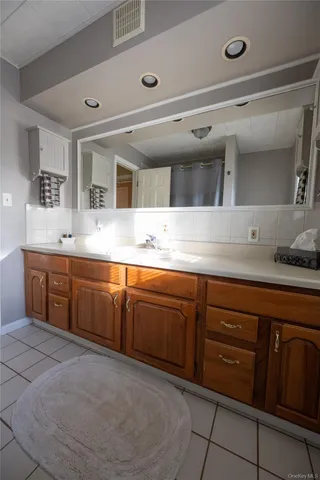 a spacious bathroom with a granite countertop sink and a mirror