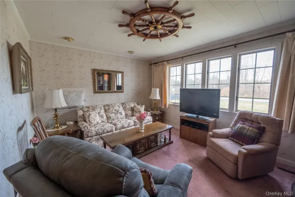 a living room with furniture ceiling fan and a flat screen tv