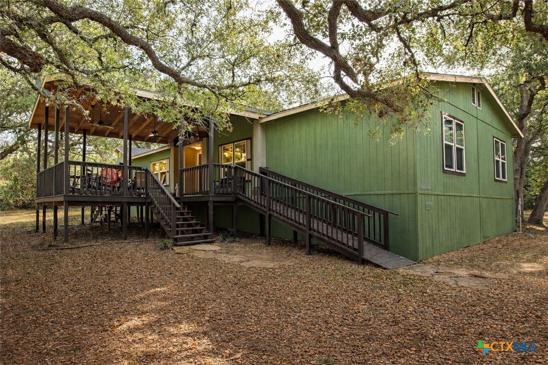 a view of backyard with deck and outdoor seating