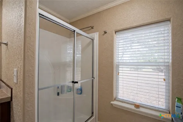 a bathroom with a shower and a window